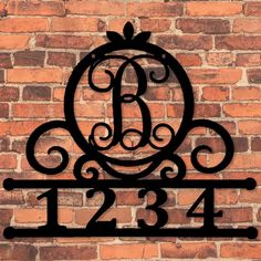 a wrought iron monogram on a brick wall