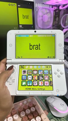 a person holding up a game system with the word brat on it