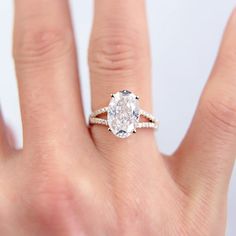 a woman's hand with a diamond ring on top of her finger and an engagement band