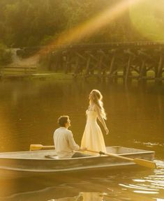 a man and woman in a row boat on the water with sun flares behind them