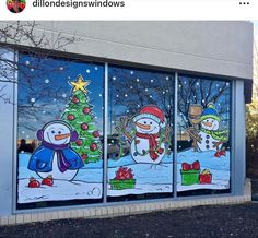 three frosted glass windows with snowmen and christmas trees on them, all decorated in different colors