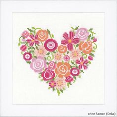 a cross stitch heart with flowers in it