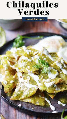 tortilla shells with cheese and cilantro sauce on a black plate