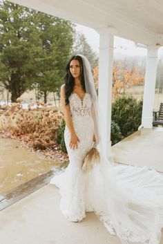 a woman in a wedding dress standing on a porch