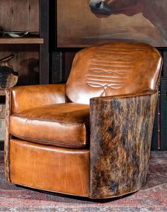 a brown leather chair sitting on top of a rug next to a wall mounted horse head