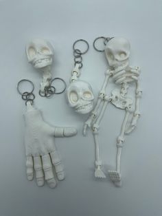 skeleton keychains with hands and bones attached to each other on a white surface