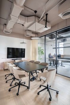 an office with white chairs and black tables