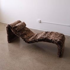 an animal print chaise lounger on the floor in front of a white wall