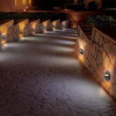 an outdoor walkway lit up with lights at night