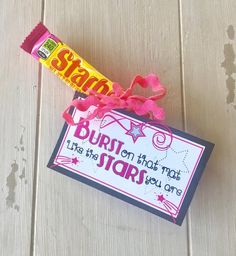 a candy bar wrapped in pink ribbon next to a sign that says, burst on that star