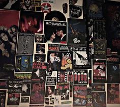 a wall covered in posters and stickers with the words kiss on it's side