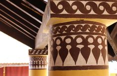 the pillars are decorated with decorative designs on them and painted in brown, white and yellow