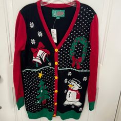 a christmas sweater hanging on a door with a snowman and tree design in the front