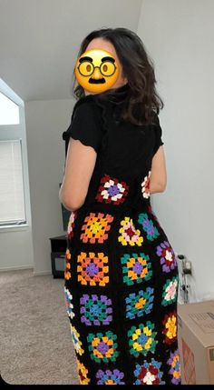 a woman with an emoticive smiley face painted on her face is standing in front of a box