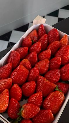 a box full of strawberries sitting on top of a table