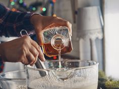 a person pouring something into a glass bowl