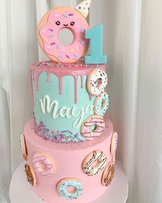 a birthday cake decorated with donuts and sprinkles for a one year old