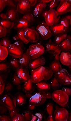 close up view of pomegranates with water droplets on them in red