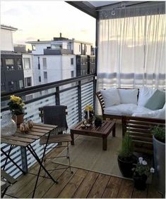 a balcony with wooden furniture and white curtains