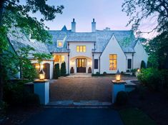 a large white house with lots of windows and lights on it's front door