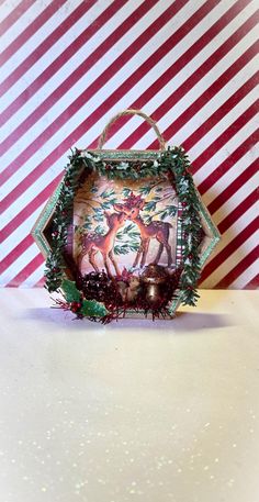 an ornament with deer and holly on it