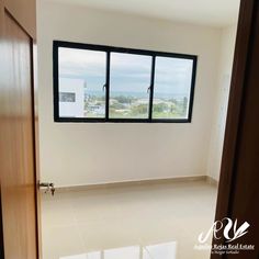 an empty room with three windows and no curtains on the door, in front of a white tiled floor