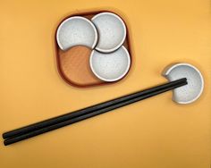 chopsticks and bowls on a yellow surface