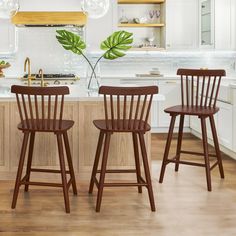 three wooden stools sit in the middle of a kitchen