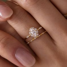 a woman's hand with a diamond ring on top of her finger and an engagement band