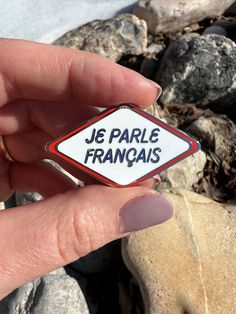 This enamel pin has the words "je parle français" (meaning "I speak French") in navy blue against a clean white background, surrounded by a happy red boarder and gold or silver metal. It is a diamond shape, measuring 1.75" across and 1" high. It affixes with two butterfly clasps. The design was inspired by the blue maker's mark on the bottom of clean white ceramic pottery, and the idea of fresh French laundry. I love languages, and I love how they help us connect with each other. I designed this Action Board, Teacher Aesthetic, Manifesting Vision Board, Speak French, French Aesthetic, French Laundry, Working In Retail, French Teacher, How To Speak French