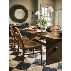 a dining room table with chairs and a mirror on the wall in front of it