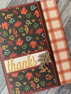 a handmade thank card with leaves and plaid paper on the bottom, in front of a wooden background