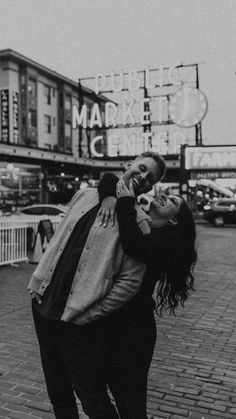 black and white photograph of two people kissing in front of marquee theatre sign