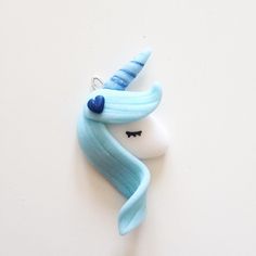 a blue and white unicorn hair ornament hanging on a wall