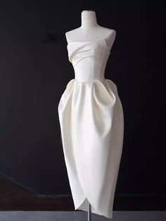 a white dress on a mannequin with a black back ground and dark background