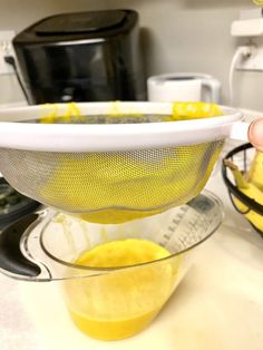 a strainer filled with lemons on top of a counter