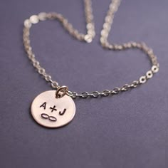 a silver necklace with the word usa on it and a smiley face drawn on it