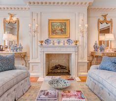 a living room with two couches and a fire place in the middle of it