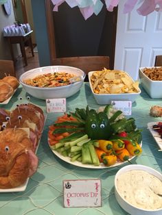 a table filled with different types of food and snacks on it's sides, including croissants