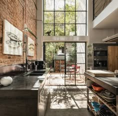 an industrial kitchen with exposed brick walls and steel counter tops is pictured in this image