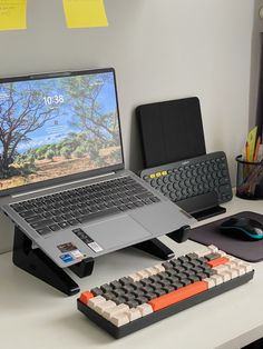 an open laptop computer sitting on top of a desk next to a keyboard and mouse