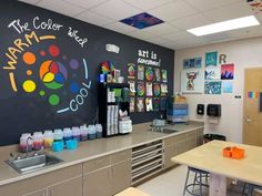 a classroom with chalkboard and art supplies on the wall