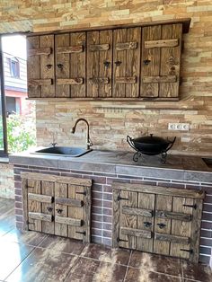 an outdoor kitchen with wooden cabinets and tile flooring on the outside wall is shown