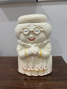 a white ceramic figurine sitting on top of a wooden table