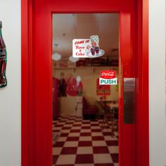 a coca cola sign is on the door of a restaurant with checkered flooring