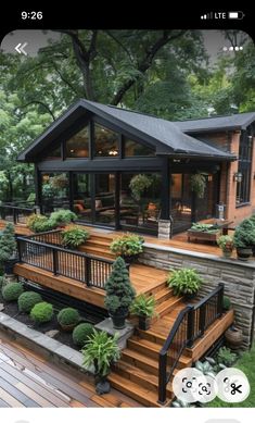 an image of a house with plants on the deck and trees in the back yard