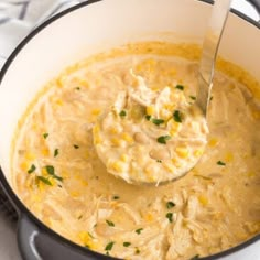 a pot filled with soup and a ladle full of the soup is ready to be eaten