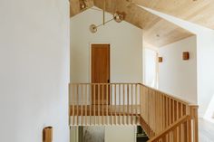 a wooden staircase leading up to the second floor in a house with white walls and wood floors