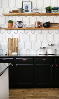 the kitchen counter is black and white with gold trimmings on it, along with two wooden shelves