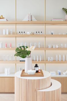 a wooden table sitting in front of a shelf filled with bottles